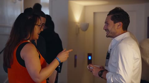 Source frame at 60.500s. Attendee conversations bracket an angled interview.